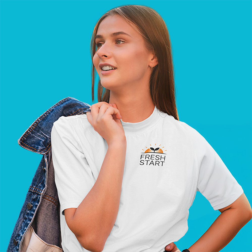 Women wearing a fresh start logo white t-shirt, holding a jacket off to the side
