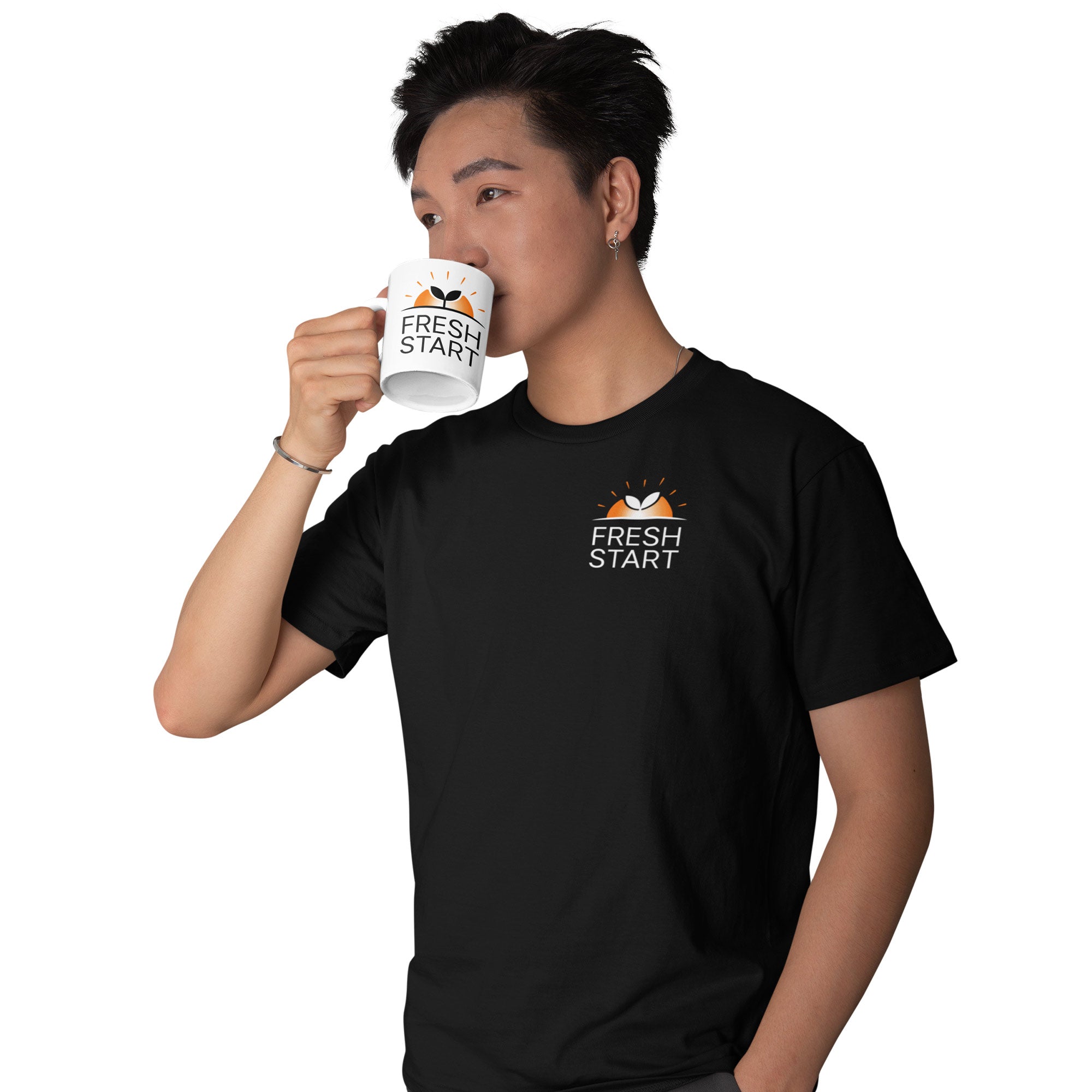 Person wearing a black t-shirt with 'Fresh Start' logo, holding a white mug with the same logo.