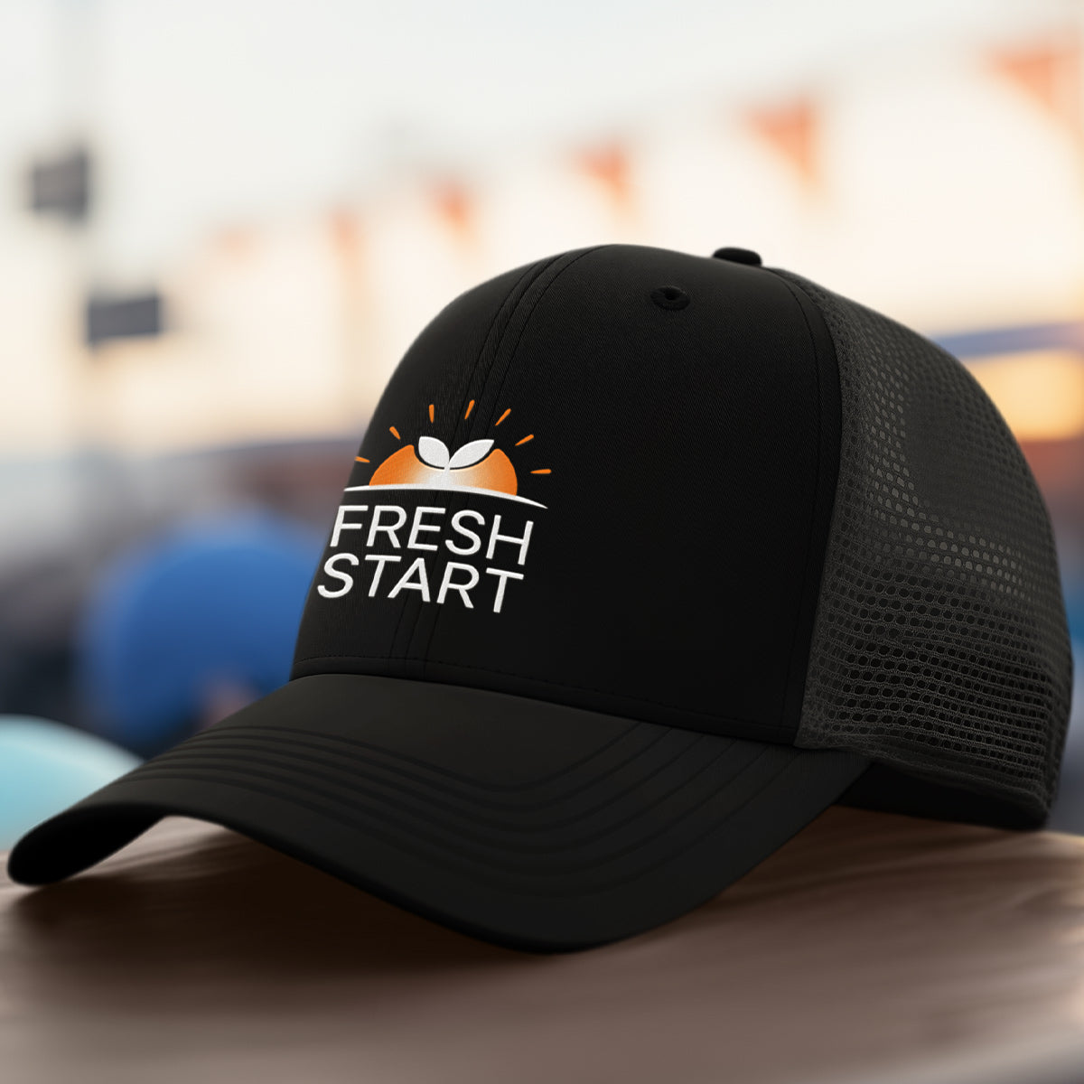 Black cap with 'Fresh Start' logo on a blurred background