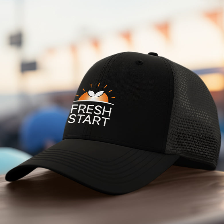 Black cap with 'Fresh Start' logo on a blurred background